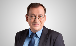 Zdjęcie przedstawia Pan Ministra MSWiA Mariusza Kamińskiego w garniturze i okularach.