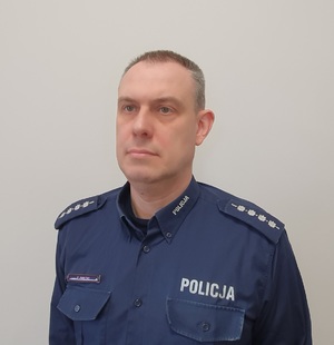 Zdjęcie przedstawia Dzielnicowego Zespołu Dzielnicowych Komisariatu Policji w Trzebiatowie w umundurowaniu służbowym bez nakrycia głowy.